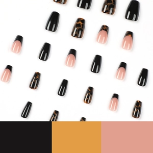 Short coffin press-on nails with black French tips, leopard print, and amber tones