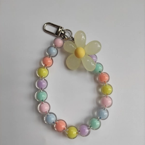 Detail of colorful transparent candy beads and yellow resin flower charm with metal clasp