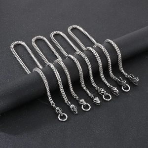Close-up of punk style titanium steel chains with skull and snake head charms