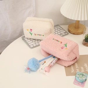Close-up of plush tulip embroidery cosmetic bags in cream and pink with Sunshine text