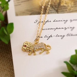 Lion pendant necklace with red gemstone eyes and clear crystals on a golden chain