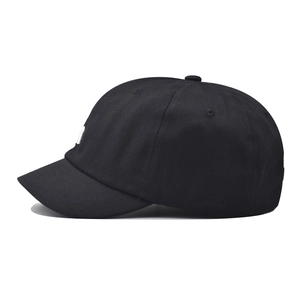Close-up of black short brim baseball cap showing white letter embroidery and cotton texture
