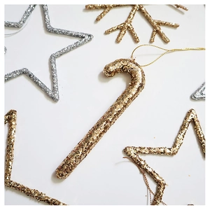 Macro detail of gold glitter candy cane ornament with sparkling holiday texture
