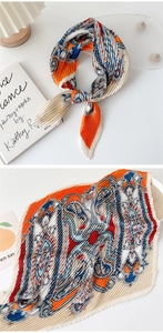 Detail of pleated silk scarf showing vintage chain patterns in orange and blue tones