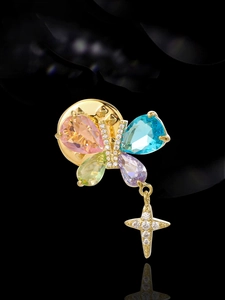 Macro shot of butterfly brooch with colorful pear-cut crystals and star pendant