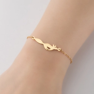 Elegante pulsera dorada con colgante de zorro en la muñeca con cadena fina de eslabones