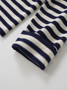 Gros plan sur le cardigan rayé bleu marine montrant le poignet côtelé et la texture