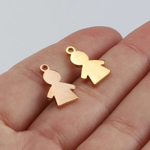 Polished gold and rose gold stainless steel boy and girl pendants shown on a finger