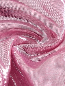 Macro shot of pink metallic knit fabric with shiny texture and soft drapery detail