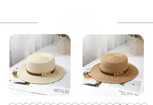 Detail of flat top straw hats in beige and khaki with leather bands and metal buckles