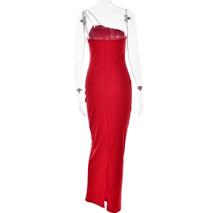 Détail de la robe rouge à une épaule avec chaîne argentée et fente à l'arrière