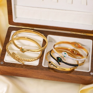 Luxurious gold-plated snake bracelet set with sparkling crystals on elegant silk background