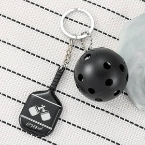 Black pickleball paddle and ball keychain with sporty metal design and engraved lettering