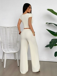 Rear view of beige short-sleeve knit top and wide-leg trousers set for women