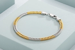 Detail of two-tone gold and silver Cuban chain bracelet with secure lobster clasp closure