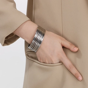 Minimalist silver multi-layered stacked steel bangle on wrist with high polish finish