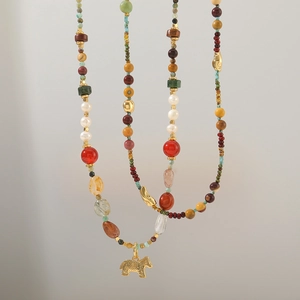 Close-up of African turquoise beads and freshwater pearls with a golden pony pendant