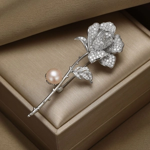 Broche élégante en forme de rose avec zircons et perle champagne dans un écrin de bijoux