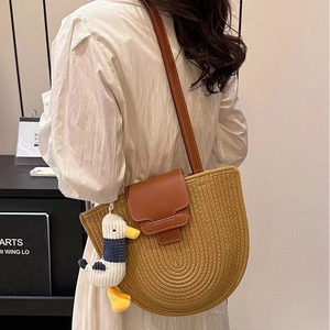 Brown semi-circular woven cotton shoulder bag with leather strap and duck charm for beach vacation