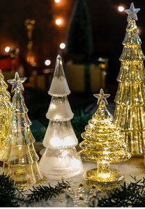 Close-up of glass Christmas tree decor with LED lights and gold glitter textures