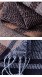 Detailed macro view showing the soft texture and fringe of the brown plaid cashmere scarf