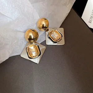 Boucles d'oreilles géométriques avec sphère dorée et cadre argenté serti d'ambre