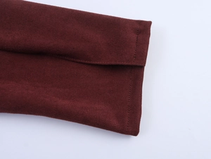 Detailed macro view of the wine red suede fabric and fine stitching on the jacket cuff