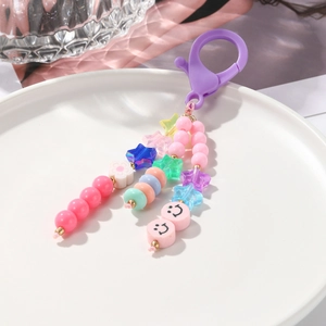 Détail macro d'un porte-clés en perles colorées avec motifs cœur et smiley rose