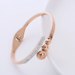 Elegante bracciale a molla lucido in oro rosa con strass scintillanti e dettagli di perle