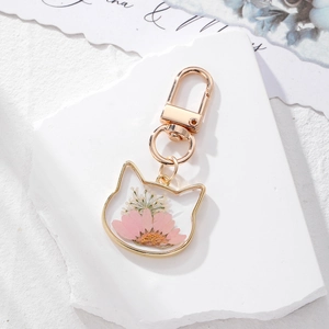 Charming cat-shaped dried flower keychain with pink daisies in a golden metal frame