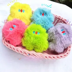 Close-up of five colorful mini plush monsters in a pink basket with detailed embroidery