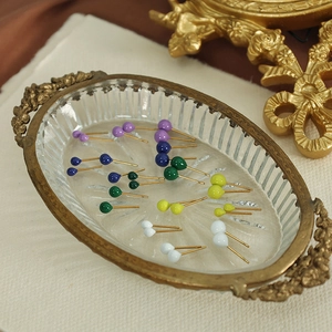 Miniature colorful enamel round bead stud earrings displayed on a vintage glass tray
