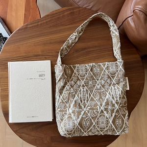 Detailed embroidery on vintage brown canvas tote with geometric and bird patterns