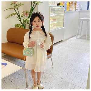 Girl in yellow dress with a cute green crossbody bag featuring a pearl handle