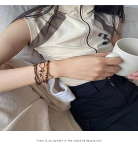 Détail de bracelets bohèmes superposés avec perles brunes et pendentif étoile en métal