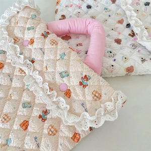 Detail of quilted laptop sleeve with lace edges, bear prints, and soft pink handle