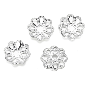 Detailed view of four silver hollow flower-shaped bead caps for DIY jewelry crafting