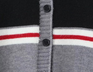 Détail du cardigan en maille rayé avec boutons noirs et texture de style collège