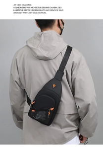 Rear view of a minimalist black sling bag with orange accents worn by a male model