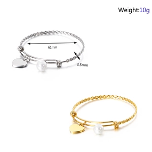 Detail view of woven steel wire bracelet with heart pendant and pearl decoration