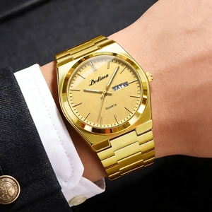 Elegant men's gold steel watch with dual calendar display worn on a wrist over a suit