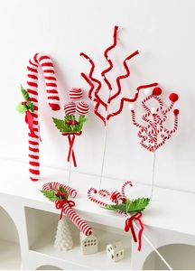 Detail of red and white plush Christmas tree picks with bows on a display stand