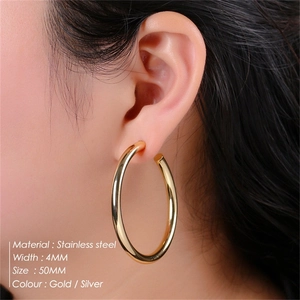 Detail shot of 50mm gold C-shaped stainless steel hoop earrings worn on ear