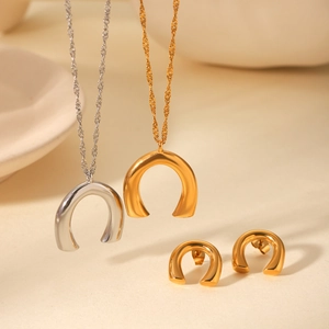 Polished U-shaped horseshoe pendant necklace and earrings set in gold and silver finish