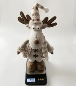 Dettaglio di un peluche renna di Natale pesato su una bilancia, mostra un peso di 426,6g