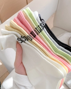 Close-up of colorful combed cotton mid-calf socks with ribbed cuffs and letter patterns