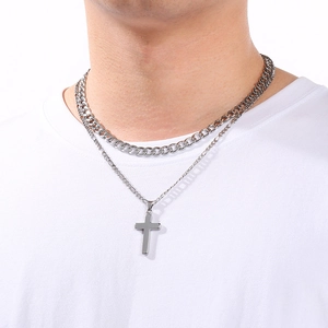 Gros plan d'un collier double épaisseur en acier inoxydable pour homme avec un pendentif.