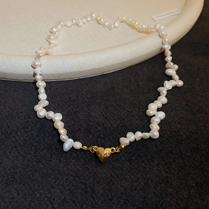 Macro detail of baroque freshwater pearls and golden heart magnetic clasp on necklace
