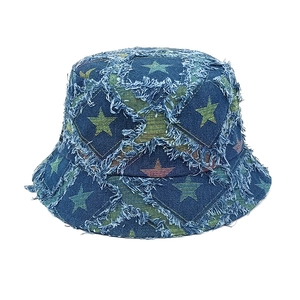 Detailed view of frayed star patterns on blue denim bucket hat with vintage texture