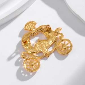 Golden pumpkin carriage brooch featuring a vintage metal design and secure pin backing
